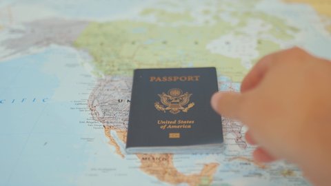 FHD Video of a Hand Putting a United States of America Passport on top of a Colorful North American Map