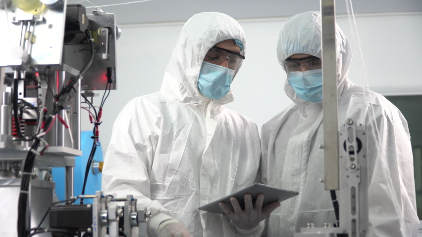 Group of engineer worker wearing ppe suite, face protective mask, glove useing digital tablet analyze  operation and check quality, Maintenance of mask manufacturing machine at lab in industry factory Royalty-Free Stock Footage #1060940743