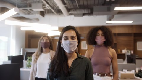 Portrait Of Female Business Team Wearing Face Masks In Open Plan Office During Covid-19 Pandemic