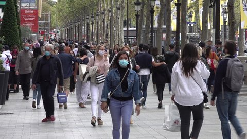 PARIS, FRANCE – SEPTEMBER 2020: Crowds of visitors walk through popular Avenue des Champs-Élysées shopping street in Paris, they are wearing compulsory face masks due to local Covid-19 regulation
