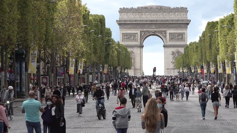 PARIS, FRANCE – SEPTEMBER 2020: Crowds of people wearing face masks (a Covid-19 coronavirus precautionary measure) walk along the famous Avenue des Champs-Élysées on car free Sunday