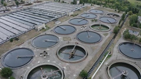 Aerial flying over a water treatment plant facility. Aeration station. Round sedimentation tanks. Sewage treatment plant 4k