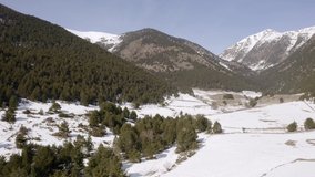 aerial view back over the forests of a snowy mountain landscape, concept of winter and beauty in nature, 4k video