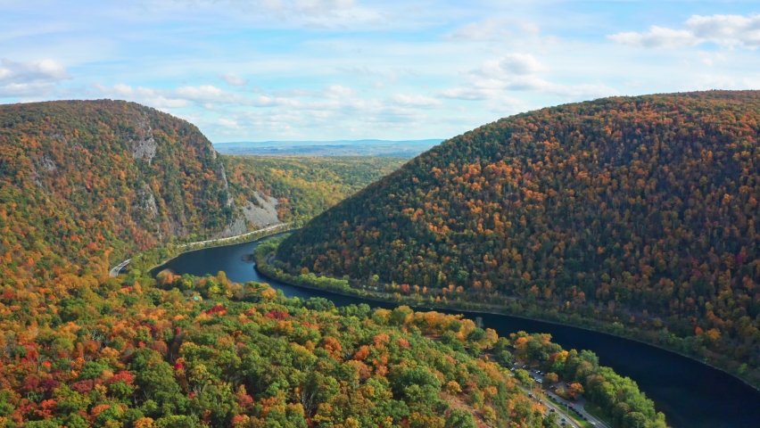 Aerial view of Delaware Water Gap on a sunny autumn day with forward camera motion. The Delaware Water Gap is a water gap on the border of the U.S. states of New Jersey and Pennsylvania - part 1 Royalty-Free Stock Footage #1060943626