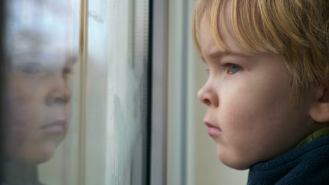 Cute Child Thoughtful Face. Serious Boy Stands Waiting Watching Looking in Window and Thinking. 2x Slow motion 60 FPS 4K