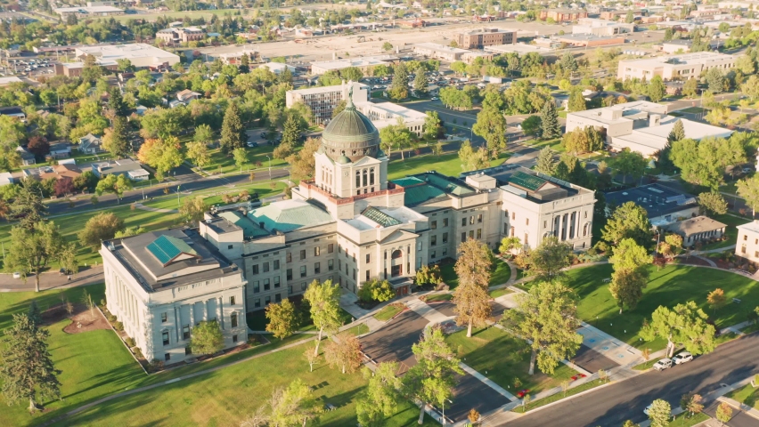 Aerial establishing shot of Montana State Capitol in Helena on a sunny afternoon with hazy sky caused by wildfires. The Montana State Capitol houses the Montana State Legislature.