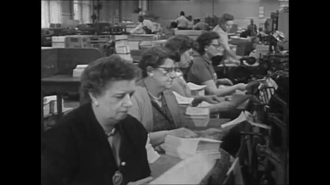 CIRCA 1960s - Female workers assemble pages and insert into a saddle for binding at a book bindery in the 1960s.