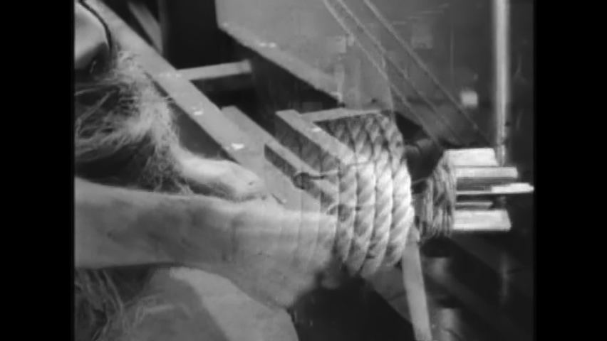 CIRCA 1940s - Machines spin hemp rope at a Rope Walk in the 1940s. Royalty-Free Stock Footage #1060952518
