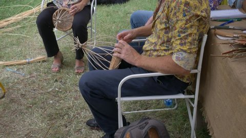 Florence, Italy - 2020, September 20: People weave baskets outdoor, during a workshop. Group activities.