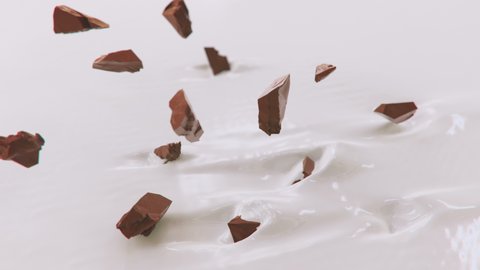 Pieces of Chocolate Splashing Into Liquid Cream in 4K Super slow motion