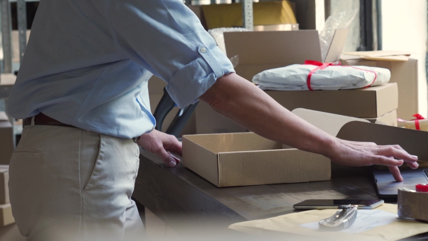 Close up view of older mature female online store small business owner worker packing package post shipping ecommerce retail order in box preparing delivery parcel on table. Dropshipping service. Royalty-Free Stock Footage #1060958167