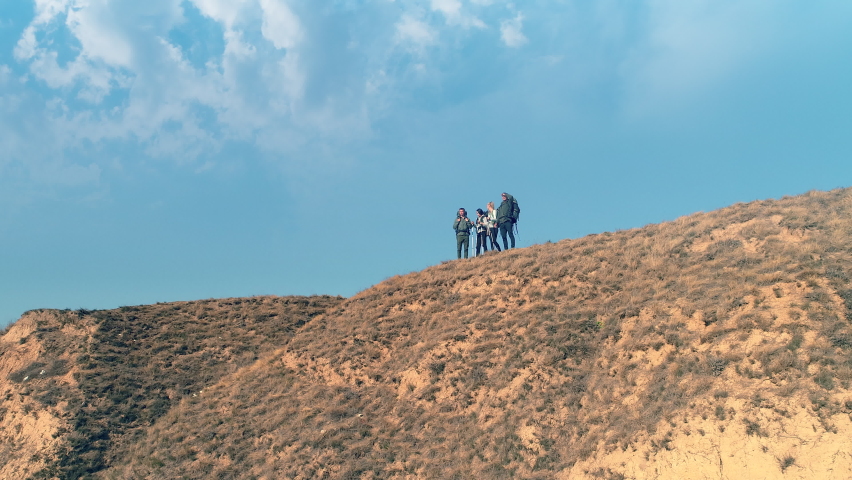 The group of four tourists walking on mountain range