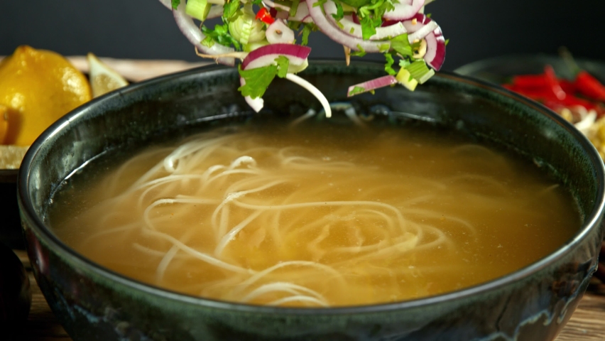 Super Slow Motion Detail Shot of Ingredients Falling into Vegetable Pho Soup at 1000 fps. | Shutterstock HD Video #1060960105