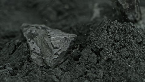 Super Slow Motion Shot of Coal Falling into Black Powder at 1000 fps.