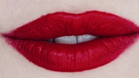 Lips with red lipstick and white teeth smiling, macro closeup of happy female smile, dental health and beauty makeup. High quality FullHD footage
