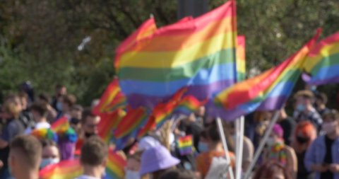 Blured unfocused crowd people with rainbow LGBT flags