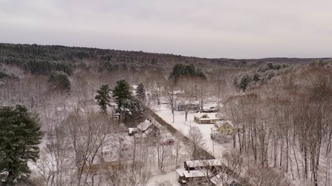 Aerial of houses and forested hills in winter in Stafford Springs, CT