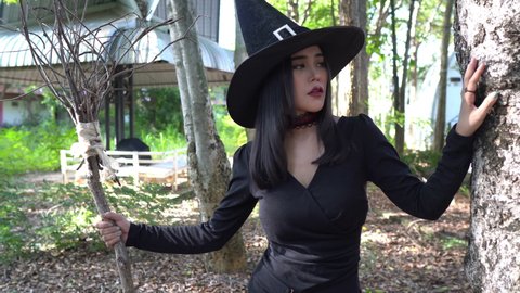 Portrait of beautiful asian sexy woman wear black witch costume with broom, Halloween festival concept