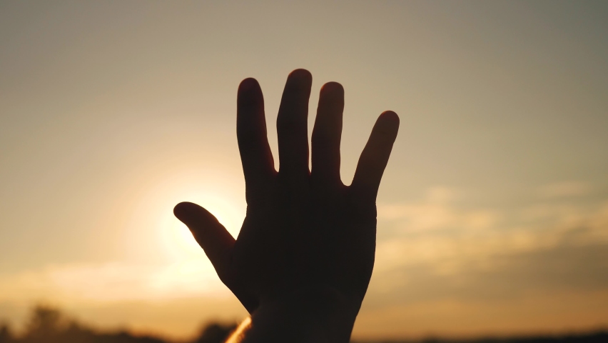 girl stretches out her hand in the sun. faith in god dream a religion sunlight concept. hand in sun the close-up silhouette dream of happiness Royalty-Free Stock Footage #1060973275