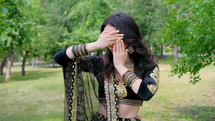 Female model in asian ethnic indian costume with  jewellery and traditional makeup. Woman dancing belly dance in oriental dress.