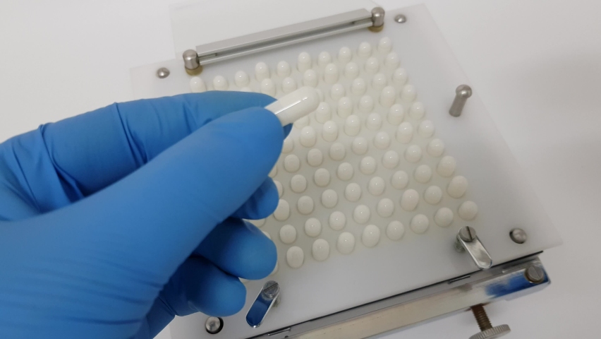 Preparation to fill pill capsules at lab. Manual capsule filler.