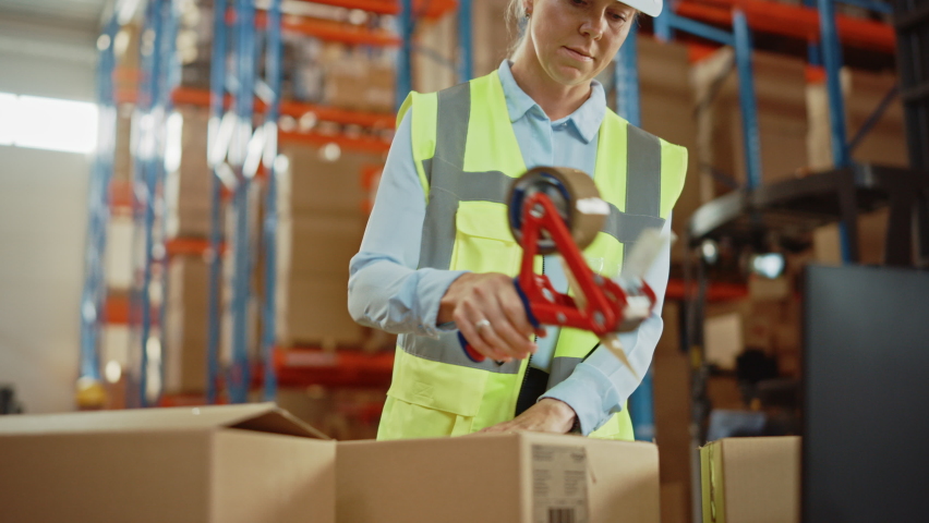 In Retail Warehouse Professional Worker Packing Parcel, Cardboard Box Sealed with Tape Dispenser Ready for Shipment. International Delivery and Distribution Center Full of Shelves with Products. | Shutterstock HD Video #1060977202