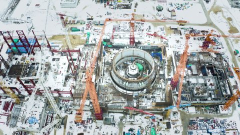 Aerial view of the construction of a nuclear power plant. Creation of nuclear power. Clean, green energy for the future. Winter carbon dioxide emissions. Ecology and pollution of nature.