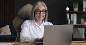 Portrait of Happy mature middle-aged Businesswoman is smiling at the Camera. Attractive old senior Female is working on Freelance from Home Office, Progressive People, World. Technology.