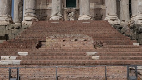 Ancient Roman Temple of Antoninus and Faustina and San Lorenzo in Miranda Church in Rome, Italy as seen from the Roman Forum, tilt up view
