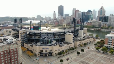 Pittsburgh , PA / United States - 10 10 2020: Aerial pan of PNC Park, home of Pittsburgh Pirates MLB team. Urban city skyline in distance, Roberto Clemente bridge crosses Allegheny River.
