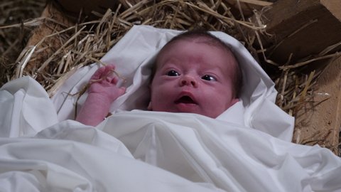 4K Gimbal: Baby Jesus laying in a Manger with straw and Hay. Christmas Nativity Scene in the stable. Top View