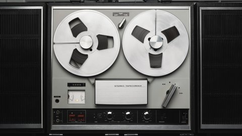 Reel to reel tape recorder playing. Rotating vintage music player close up. Retro tape. Spinning reels metallic color. Party. Loop. Front view. Front view. Popular Disco Trends 60s, 70s, 80s, 90