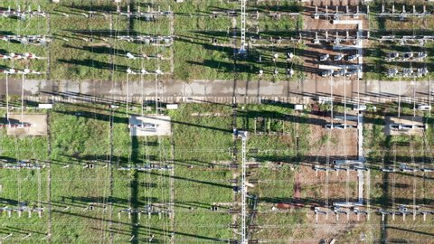 Electrical substation - grid of high voltage power lines and wires. Long-range energy transmission. Aerial top down view.