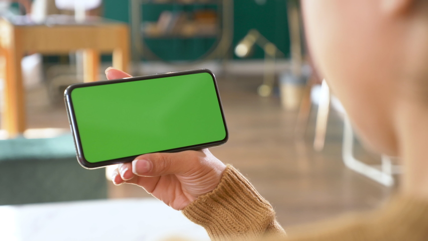 Close up Horizontal hands holding smartphone with green screen. Green screen mobile phone with chroma key. Perfect for product placement. Royalty-Free Stock Footage #1060997980