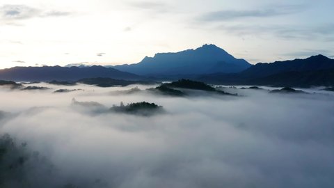 Aerial 4k footage of beautiful sunrise with Mount Kinabalu as background in rainforest jungle with foggy and cloud at Sabah, Borneo