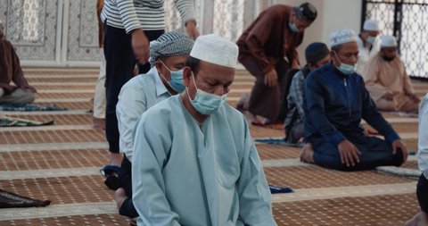 Kuala Lumpur, Malaysia - October 4th, 2020 : Asian Muslim people performing pray in mosque, wearing mask and social distancing, prevention of Covid 19 outbreak during pandemic.