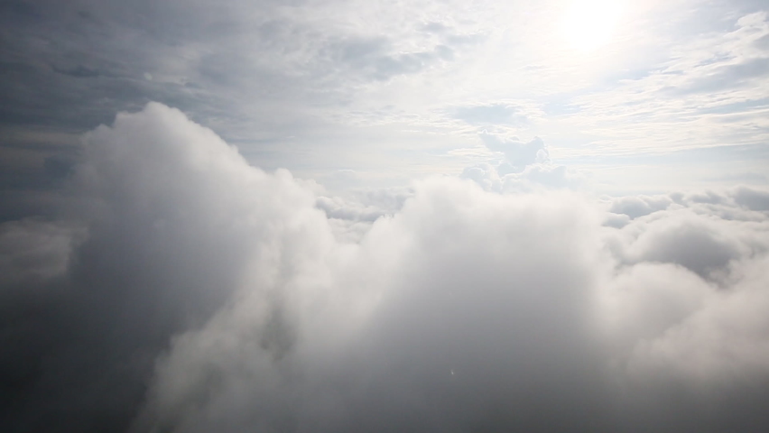 Thick, puffy clouds as seen from inside bloud ceiling with helicopter. Bright sunlight glow entering frame from above, giving a divine mood, possibly usable in religious / redemption context. Royalty-Free Stock Footage #1061008405