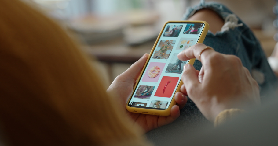 woman hands using smartphone browsing online scrolling social media picture gallery looking at creative ideas on mobile phone screen at home