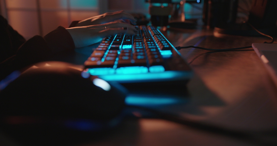 close up hands typing on keyboard programmer coding software gamer using keyboard with blue backlight playing game at night Royalty-Free Stock Footage #1061018410