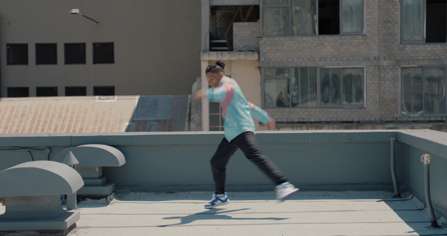 dancing man breakdancing on roof top hip hop dancer practicing dance routine performing freestyle moves in city Royalty-Free Stock Footage #1061018653