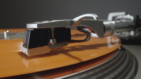 Close up footage orange vinyl record playing on record player, turntable, vintage, retro