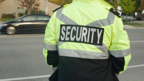 Security guard patrolling street next to highway