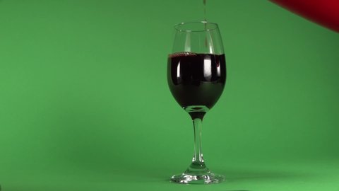 Pouring wine on a glass, in chroma background.