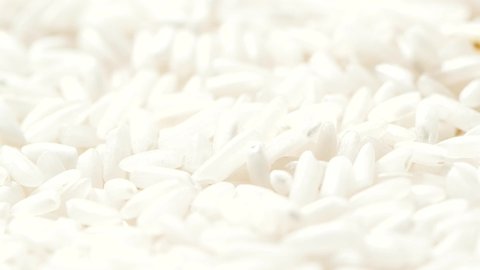 Macro white raw rice grain falling down, food background, slow motion video