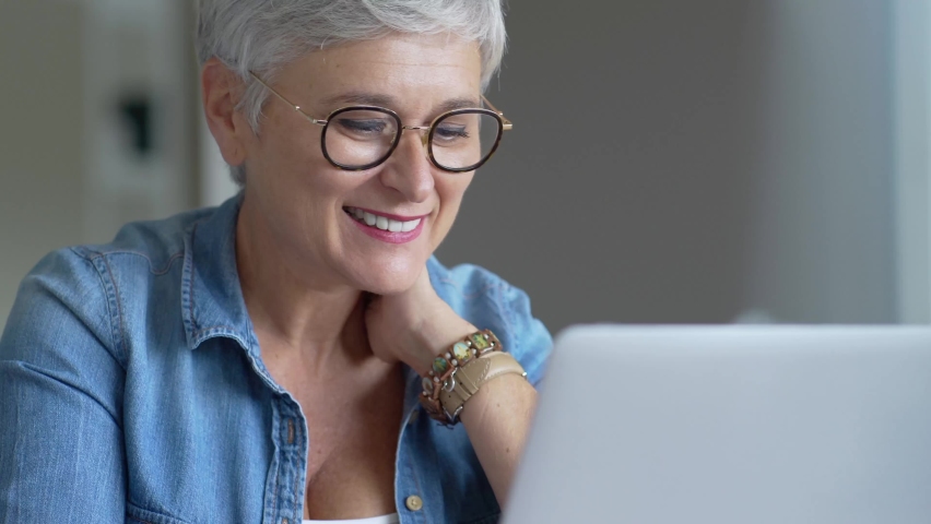 Portrait of a beautiful mature 50-year-old woman with white hair working from home | Shutterstock HD Video #1061041585
