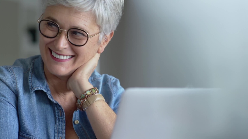 Portrait of a beautiful mature 50-year-old woman with white hair working from home Royalty-Free Stock Footage #1061041621