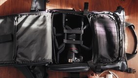 Photographer packs photography equipment into backpack. Top view.