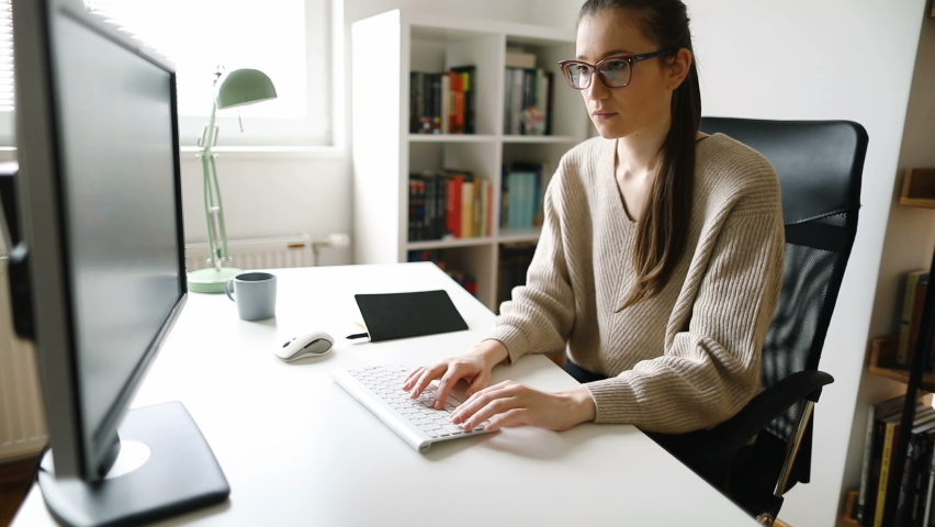 Young woman working on computer at her home office	 | Shutterstock HD Video #1061049712
