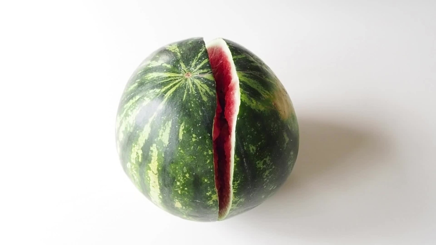 
open watermelon with hands on white table