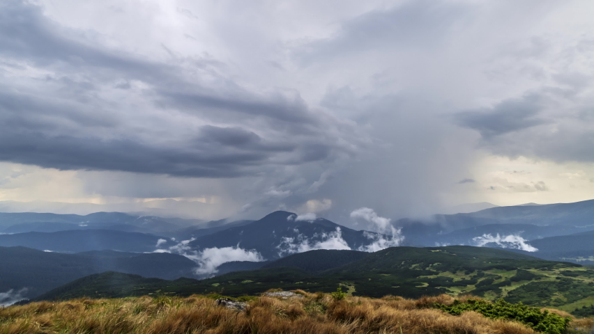 Rain thunderstorm clouds moving over the mountain hills with fog timelapse summer mountains nature landscape, green grass hiking outdoor travel panorama view. Carpahian Europe. High quality 4k footage